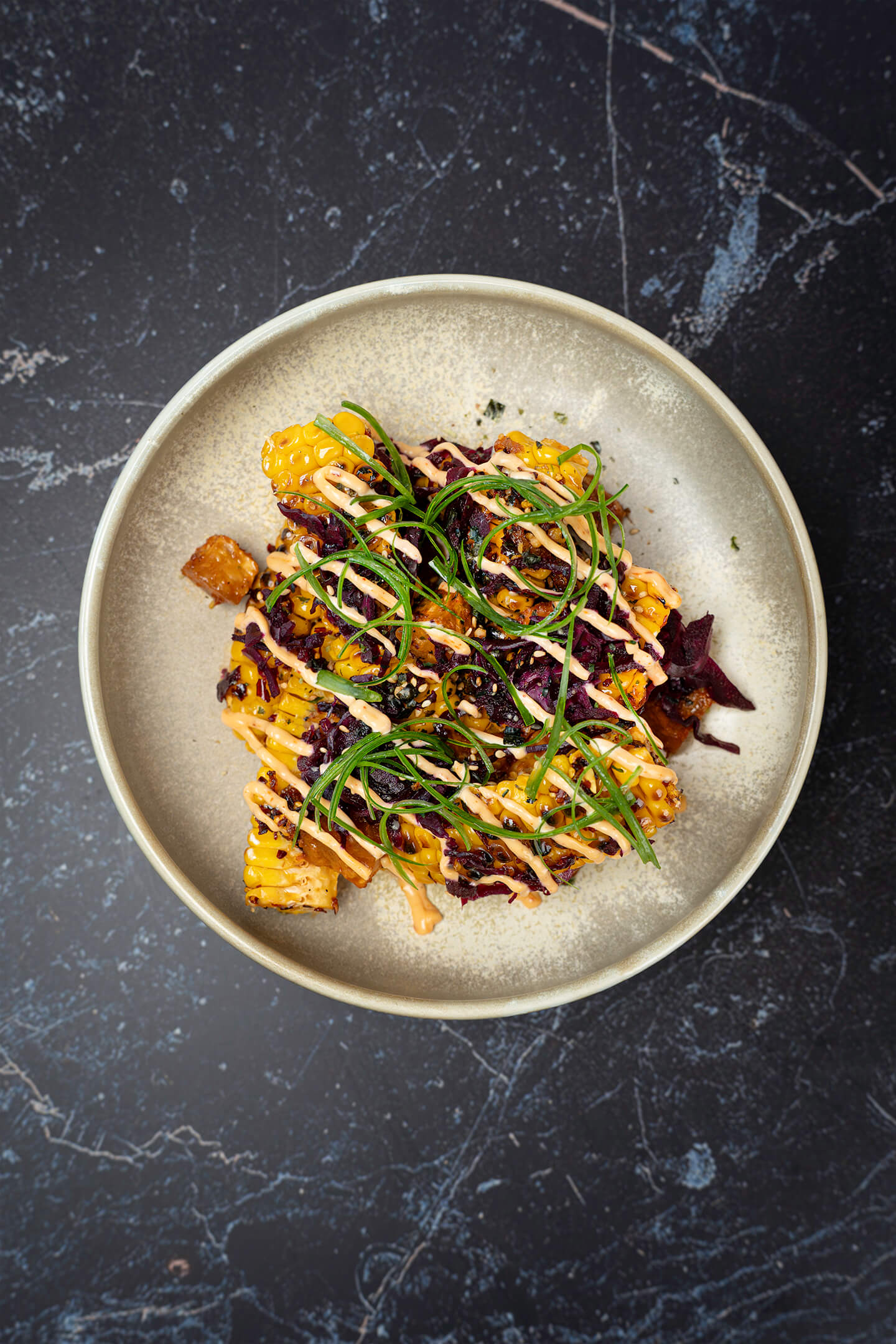 Corn ribs van de BBQ met crispy chili olie, rode kool kimchi, geroosterde knolselderij en furikake