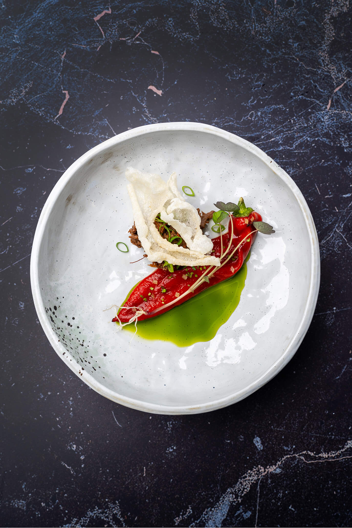 Gochujang gestoofde runderriblap met rijstkrokant, olie van lente-ui en gepofte puntpaprika