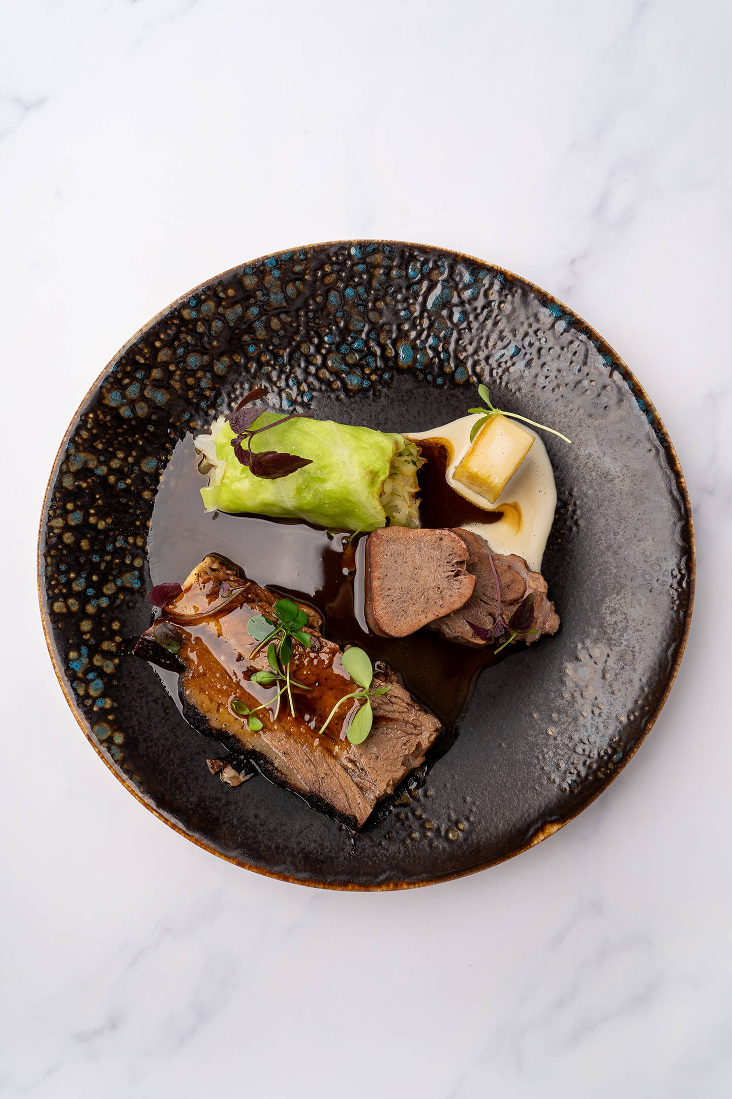 Brisket en gerookte kalfstong met spitskool en zwarte peper jus