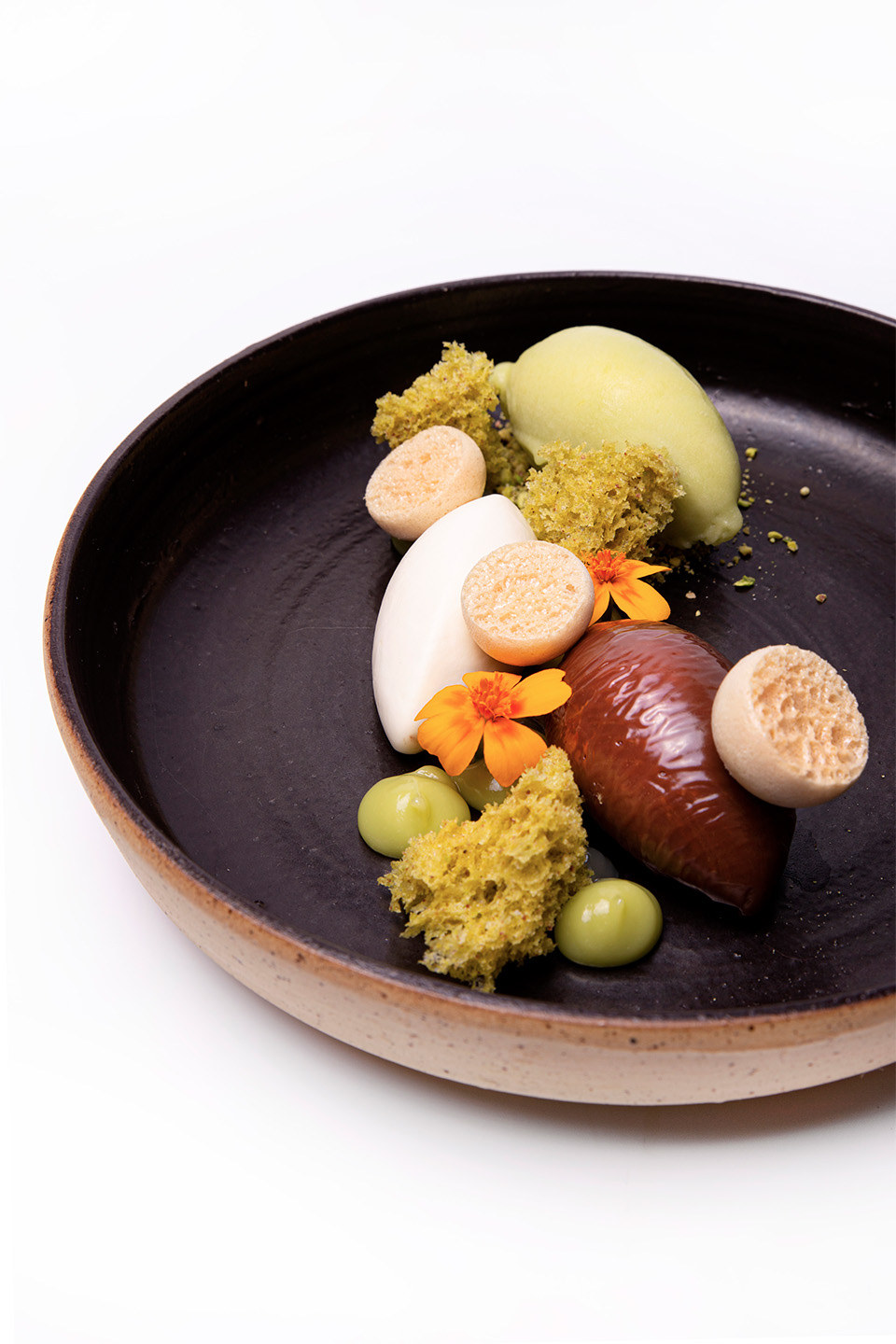 Dessert van avocado met koffie, melkchocolade, kokos en pistache