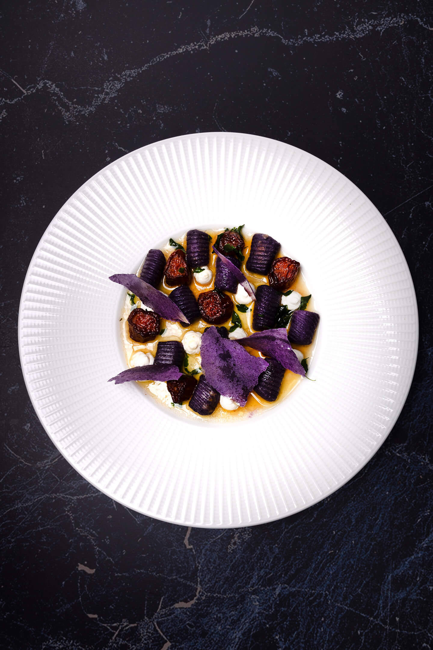 Paarse aardappel gnocchi met dressing van tomatenmolasse en beurre noisette, ricotta crème en aardappel papier