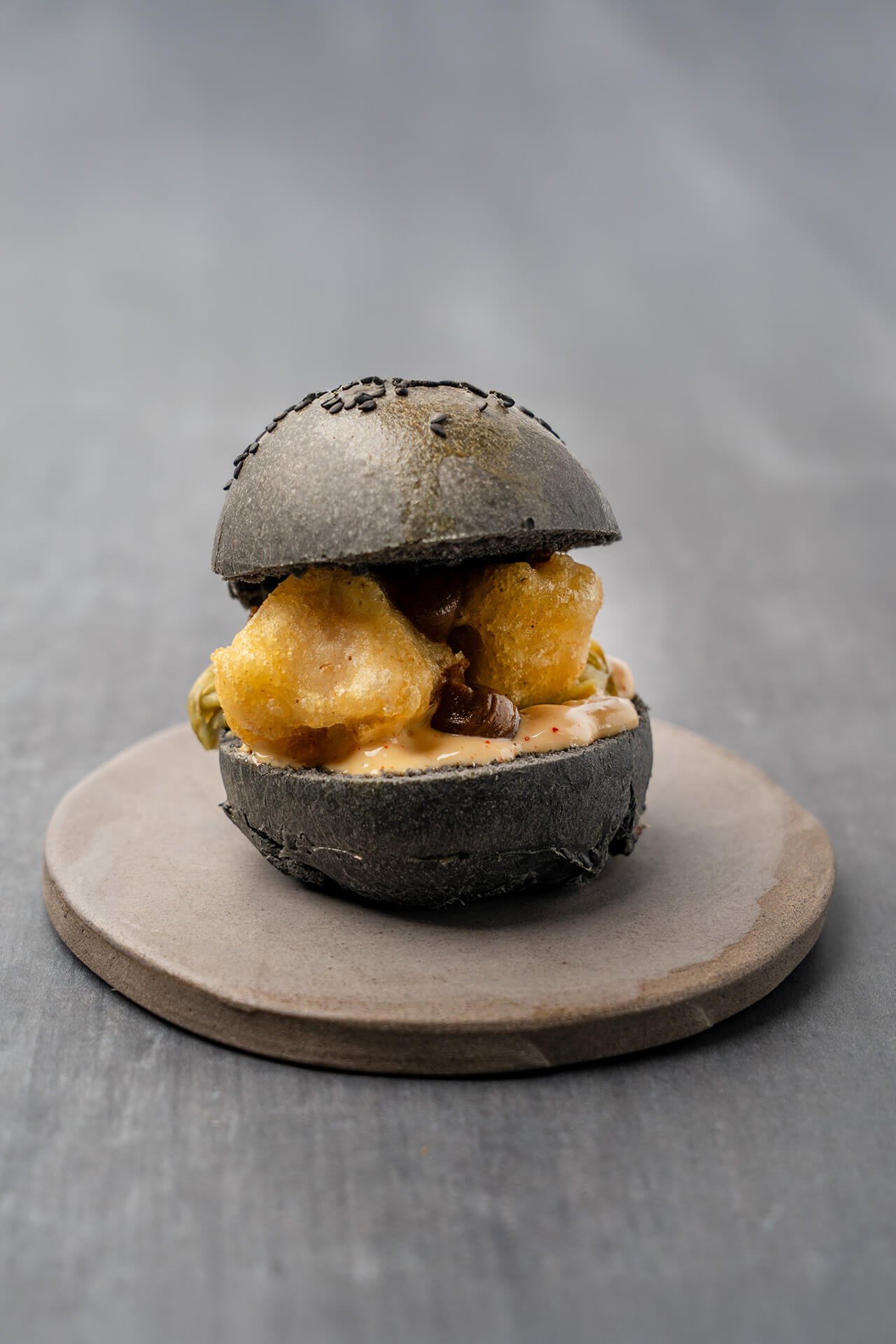 Korean fried kalfszwezerik met een Japans melkbroodje van zwarte sesam en kimchi mayonaise