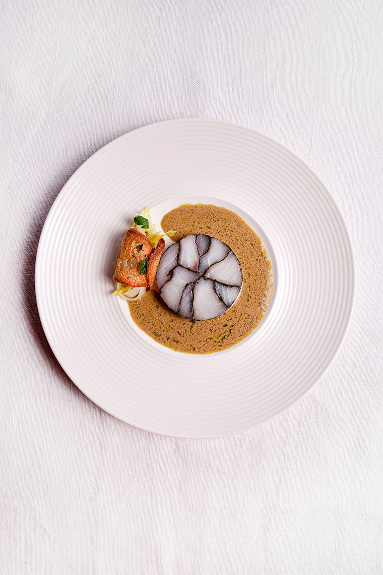 Marbled cod rouleau with a beurre blanc of black garlic and lovage oil